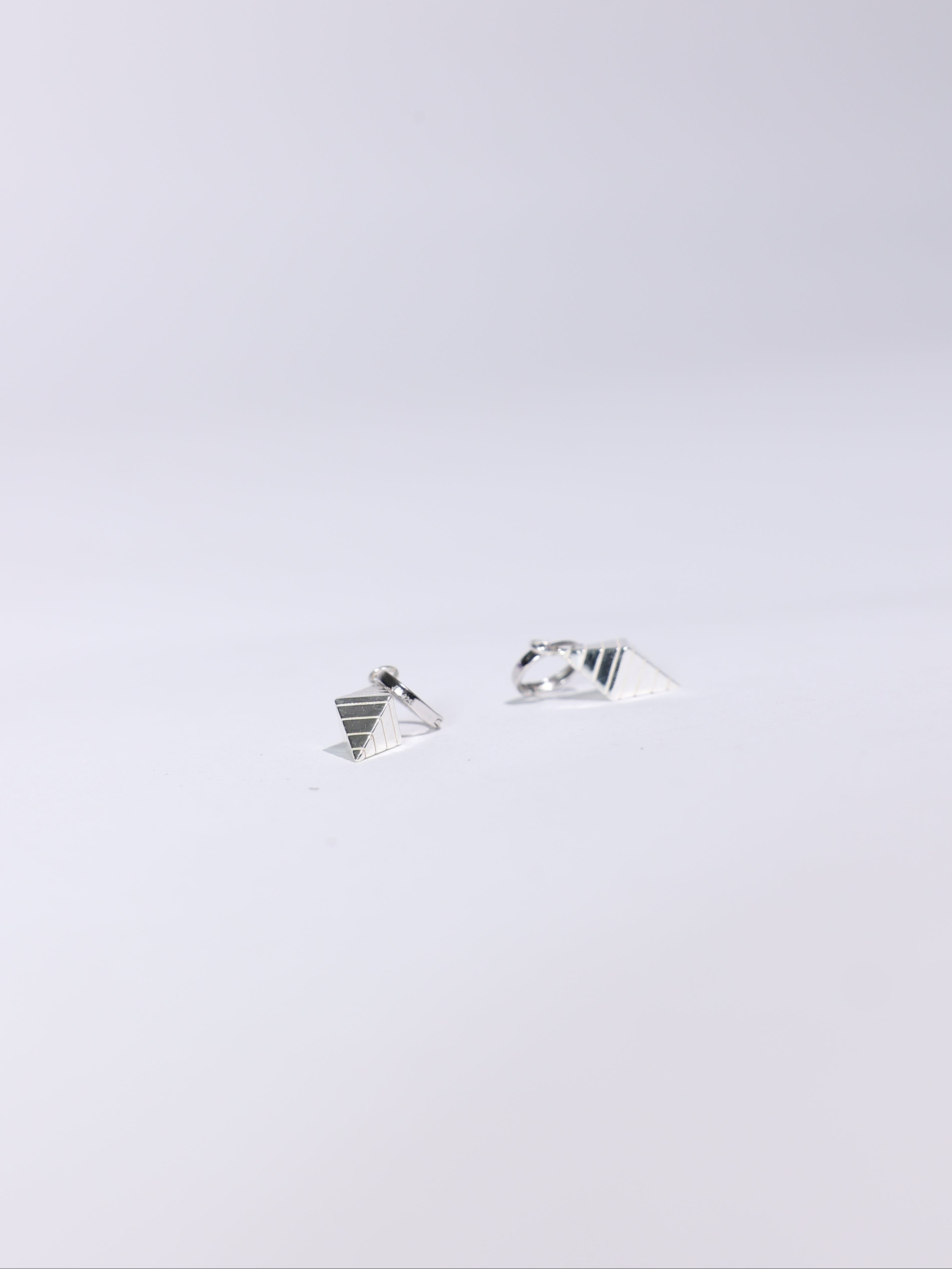 Pair of silver earrings on a light gray background
