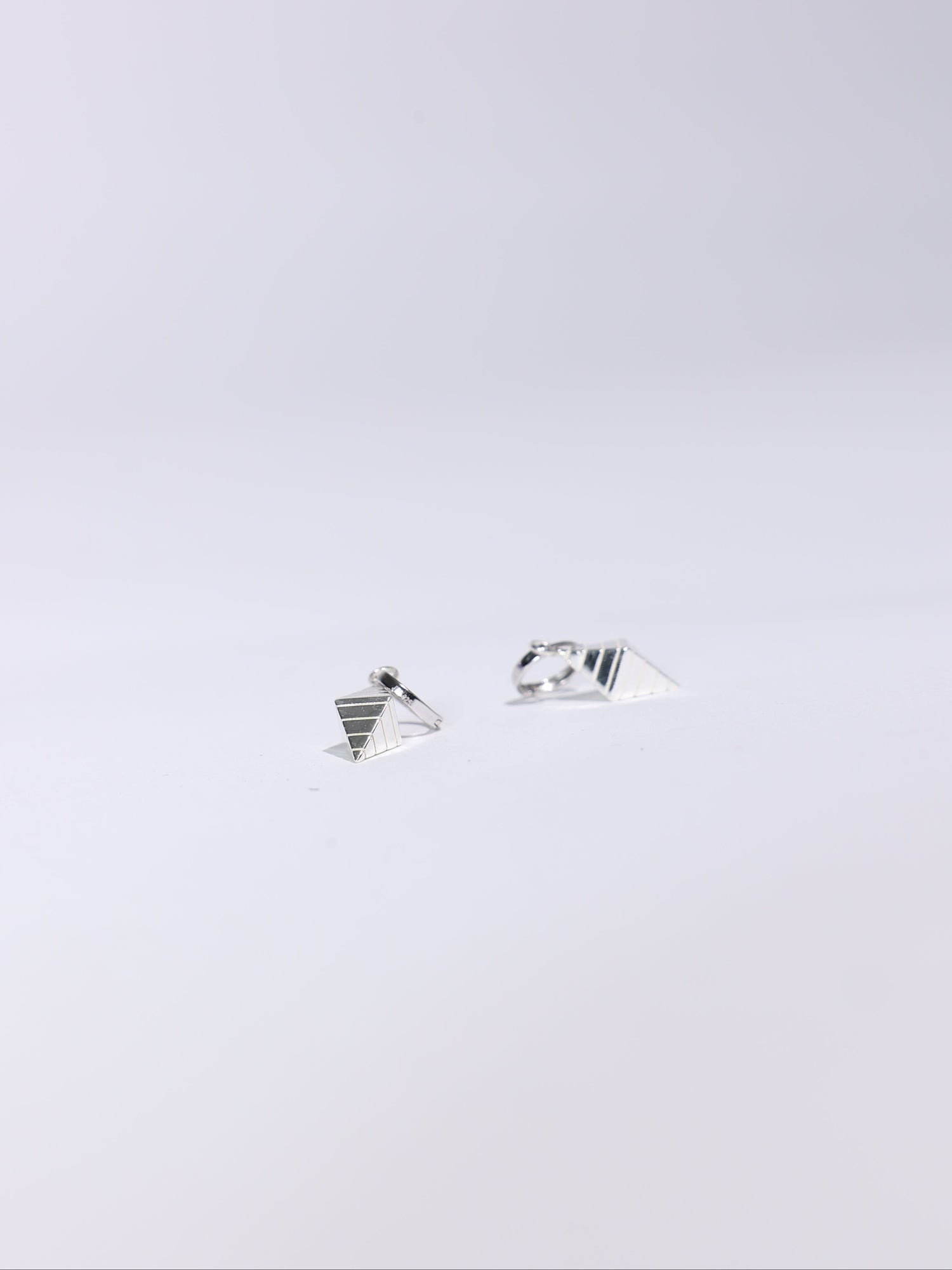 Pair of silver earrings on a light gray background